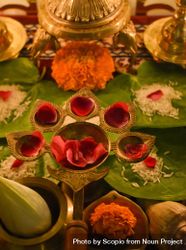 Red rose petals on diya with five candle holders bEJkA0