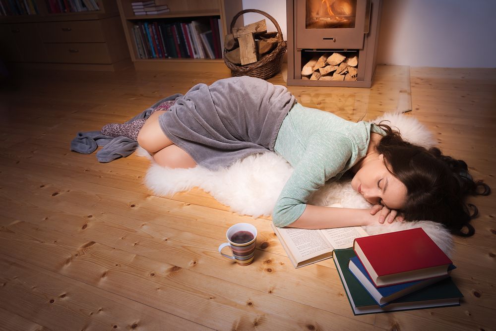 Woman sleeping surrounded by books