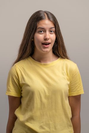 Headshot of a surprised young woman listening with interest.