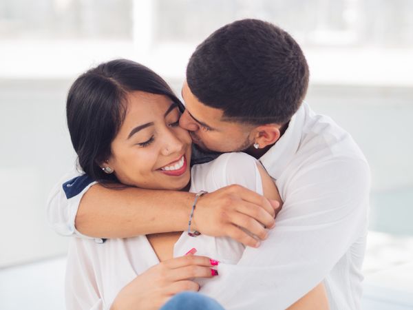 Man embracing smiling woman with love and tenderness