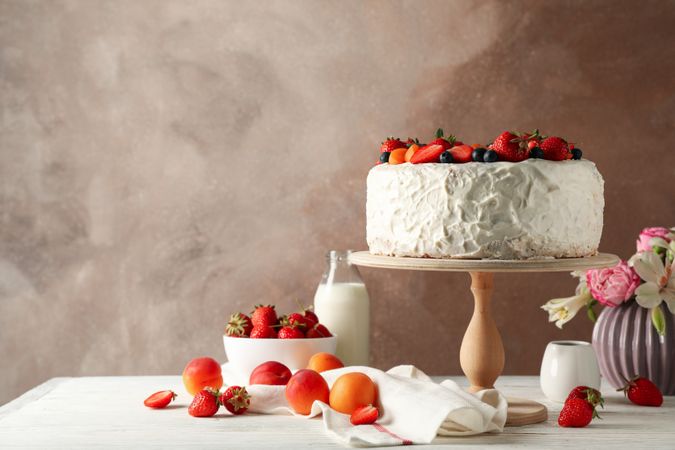 Composition with delicious berry cream cake on wooden table. Tasty dessert