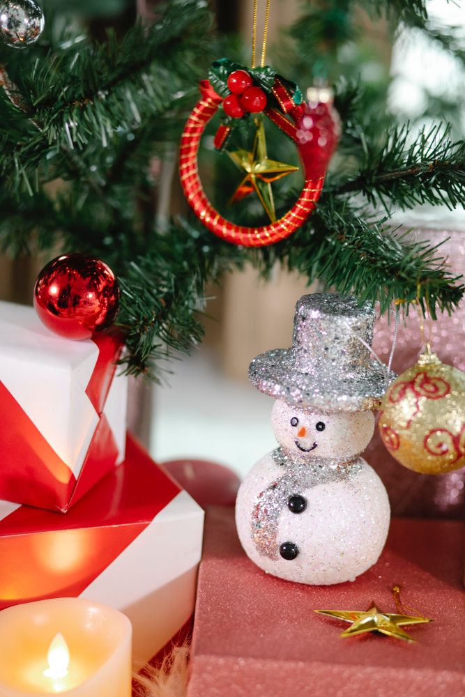 Gift boxes beside snowman and Christmas ornament
