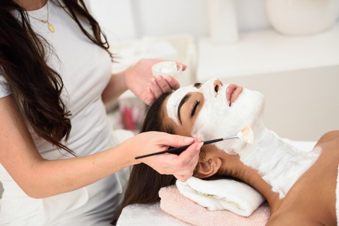 Woman applying product to client’s face with a brush