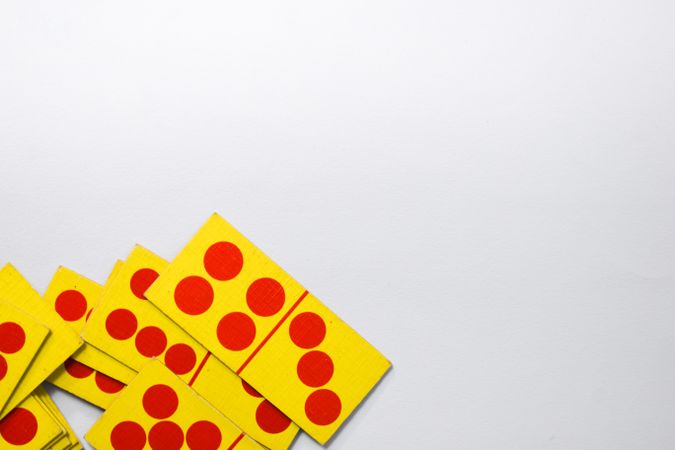 Looking down at red and yellow domino cards with copy space