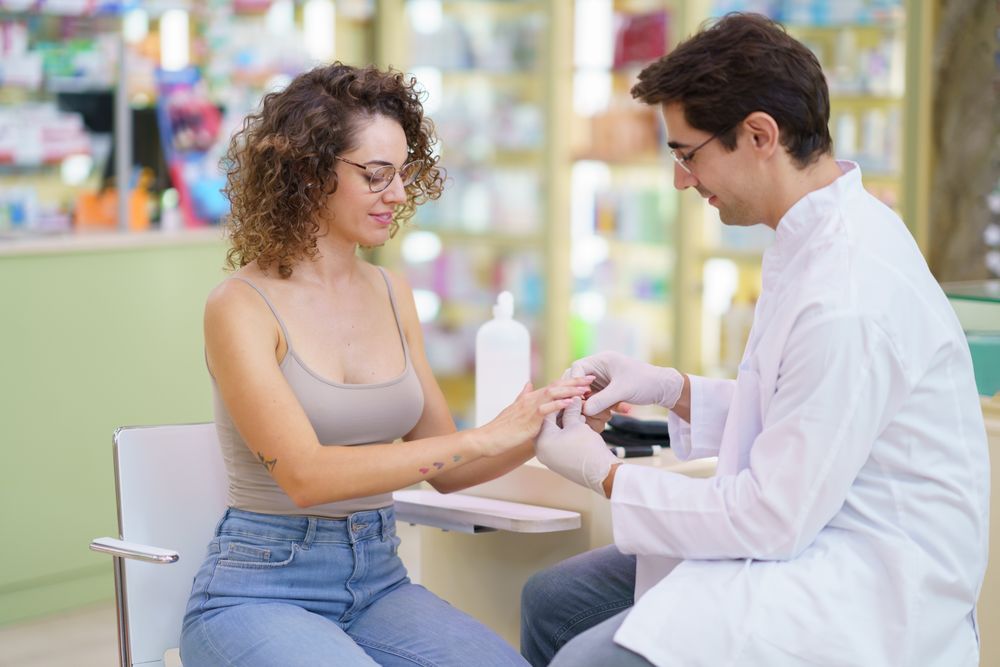 Woman having hand pricked for blood sugar test