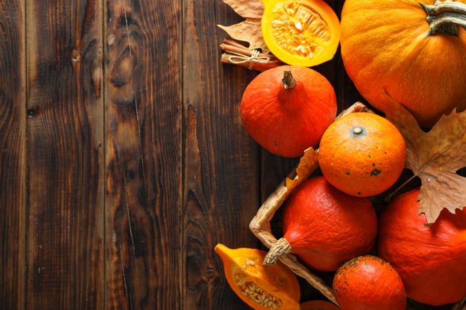 Composition with pumpkins and leaves on wooden background, copy space
