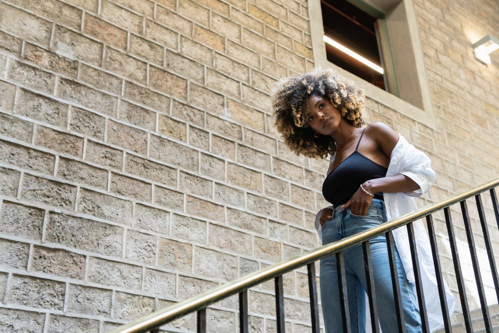Black woman standing near railing of stairway