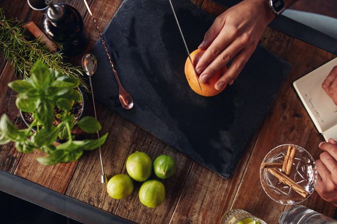 Bartender cutting a grapefruit on the chopping board