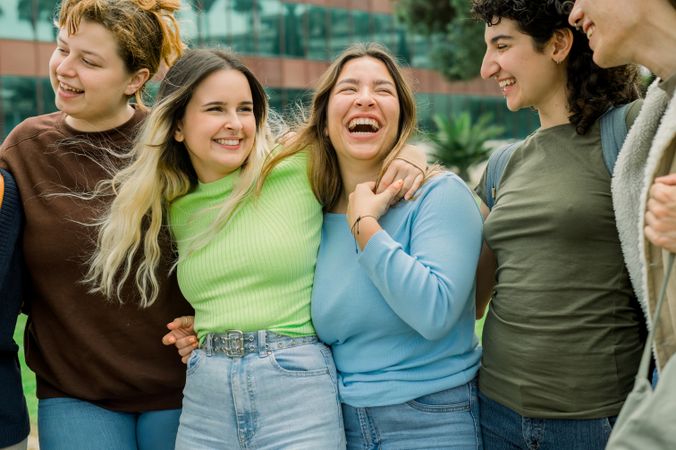 Group of diverse student friends hugging and laughing