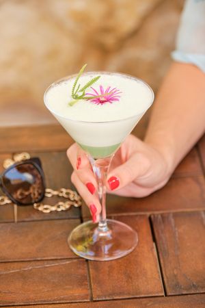 Faceless person with decorated glass of cocktail