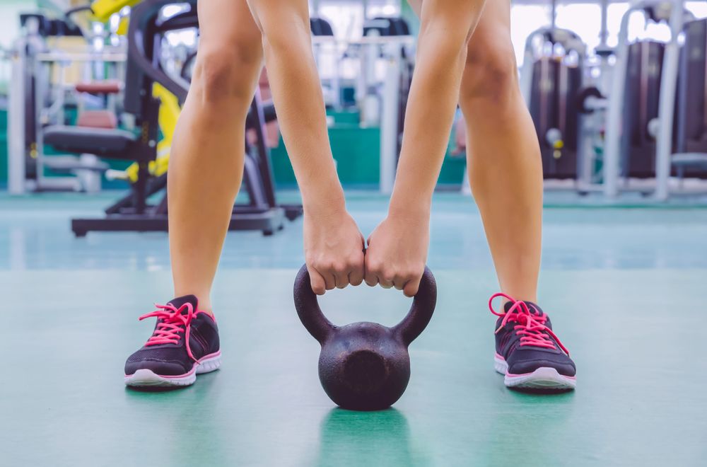 Woman lifting kettlebell off ground