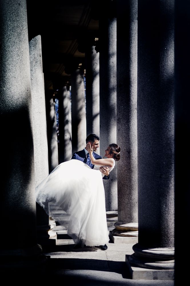 Newly weds having fun between columns