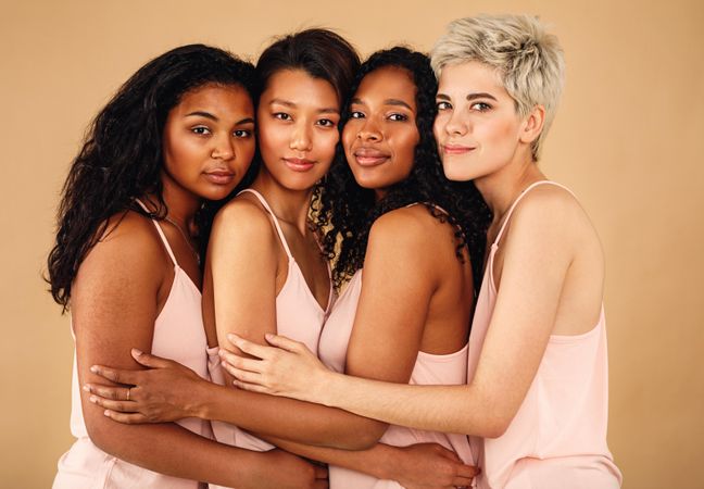 Multi-ethnic women with their arms around each other