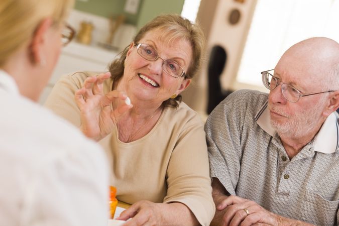 Doctor or Nurse Explaining Prescription Medicine to Older Couple