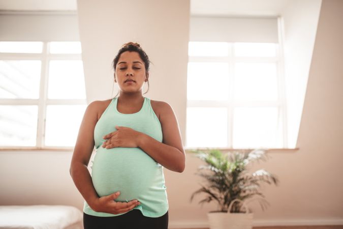 Pregnant female meditating at home