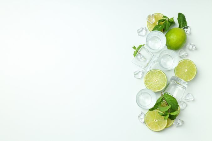 Glasses for shots and ingredients for cocktails on blank background