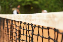 Clay tennis court with net, close up