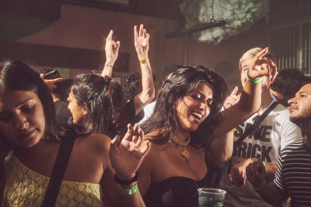 London, England, United Kingdom - Nov 9, 2022: Enthusiastic South Asian woman dancing in crowd