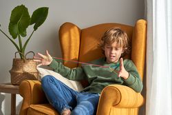 Boy looking at finger rope in bewilderment