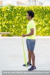 Man exercising his upper body with resistance bands outdoors 5QeZG5
