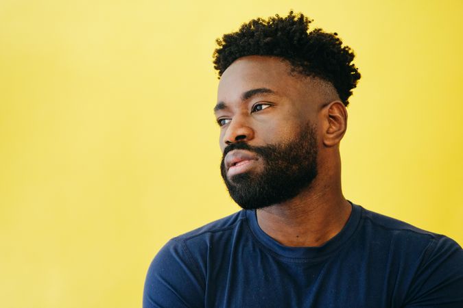 Portrait of contemplative Black man in navy t-shirt in studio shoot