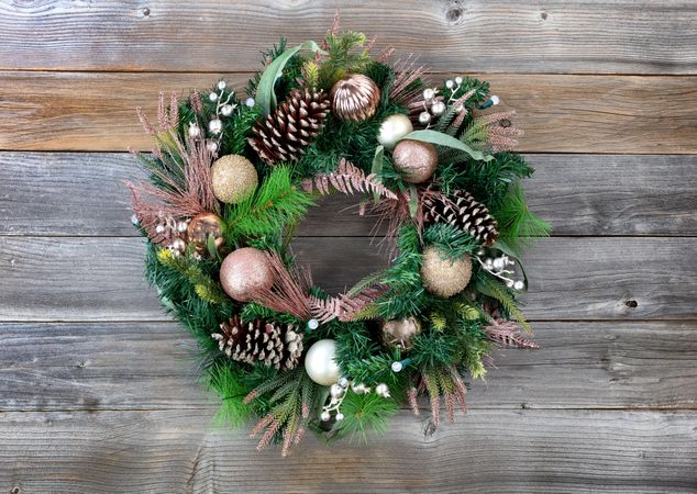 Christmas holiday wreath with illuminated lights on rustic wooden planks