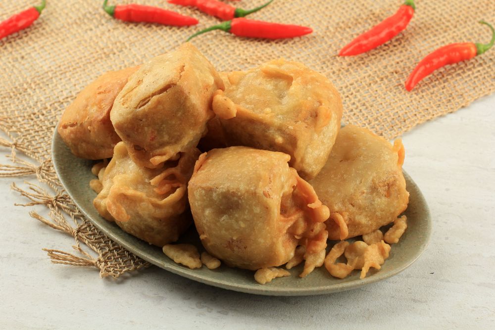 Plate of Indonesian fried stuffed tofu with chilis on the side