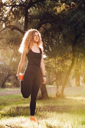 Sportive woman standing on meadow in sunlight