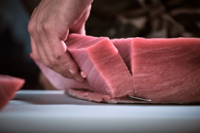 Male hands of a chef cutting a delicious loin of fresh bluefin t