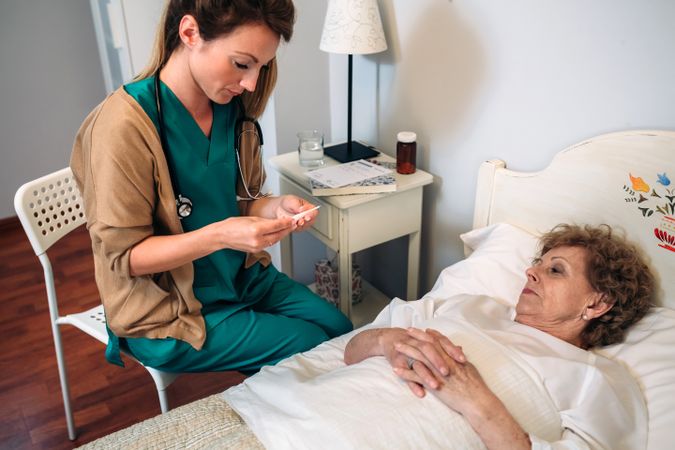 Doctor taking temperature to woman