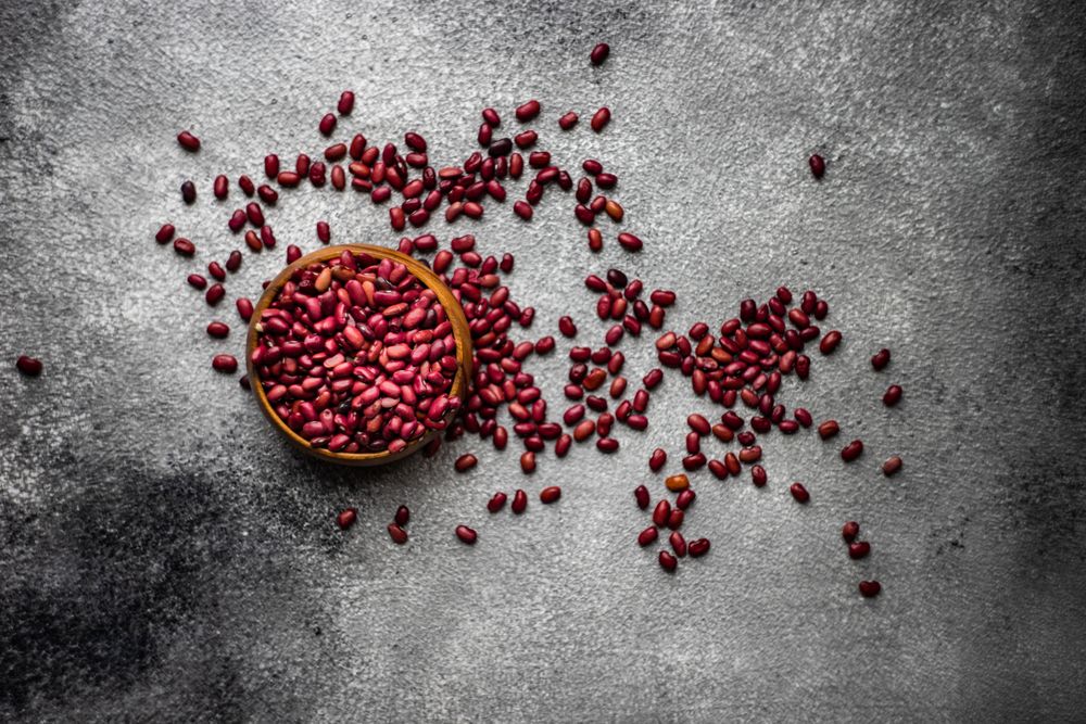 Top view of dried kidney beans spilling onto grey counter