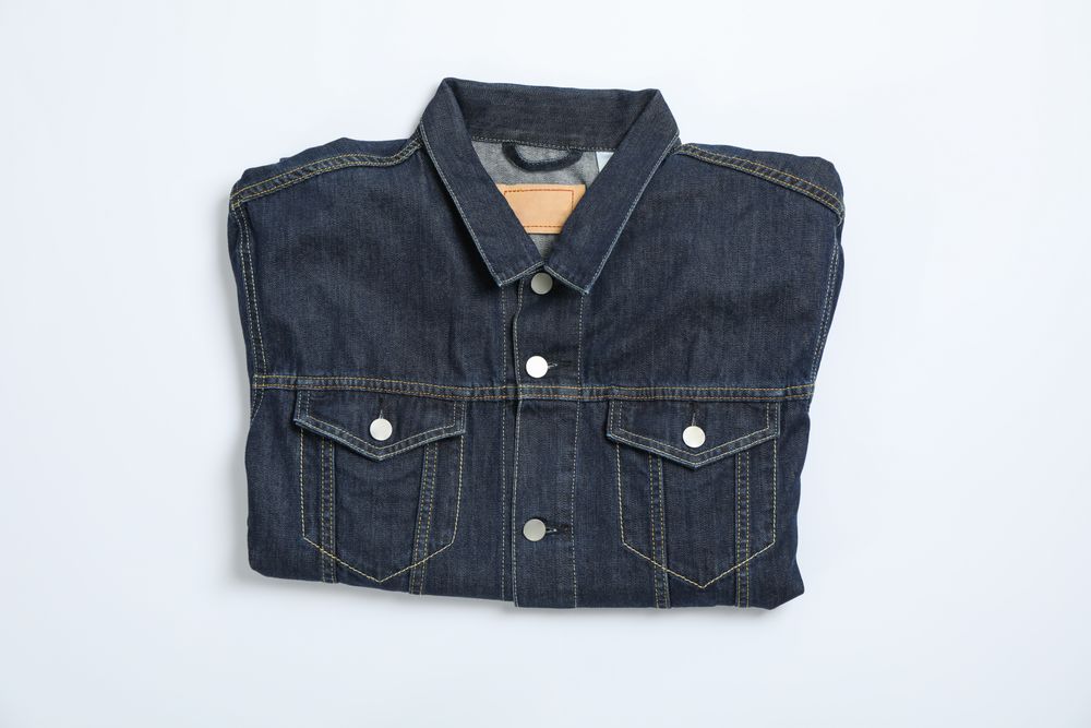 Denim jacket on light background, space for text