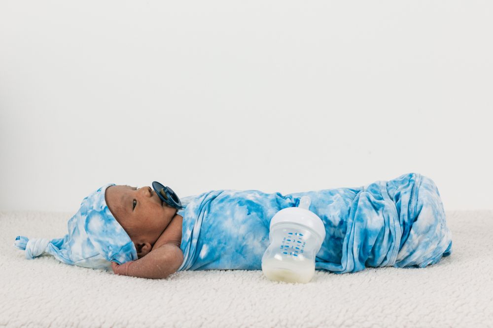Newborn baby wrapped on soft blanket with pacifier