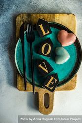 Teal plate with the word "love" and heart decorations bE99BA
