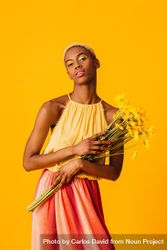 Black woman with short blonde hair holding yellow flowers 5lXRm5
