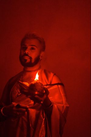 Portrait of man holding a candle in red lit room