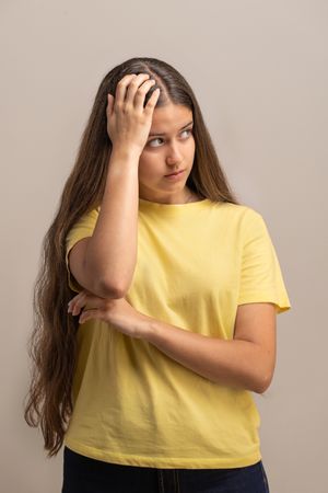 Confused and frustrated young woman scratching her head, thinking about a problem.