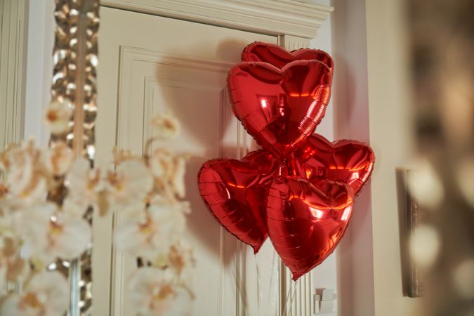 Red heart shaped balloons decorating entrance room in hotel suit