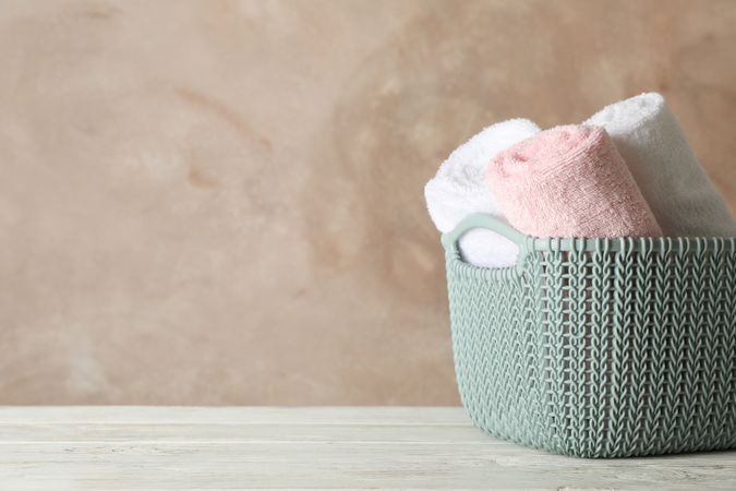 Basket with clean laundry on wooden board, space for text