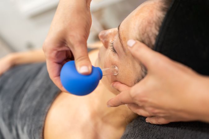 Woman receiving facial treatment in salon