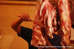 Man cutting meat in butchers shop 0gxJW5