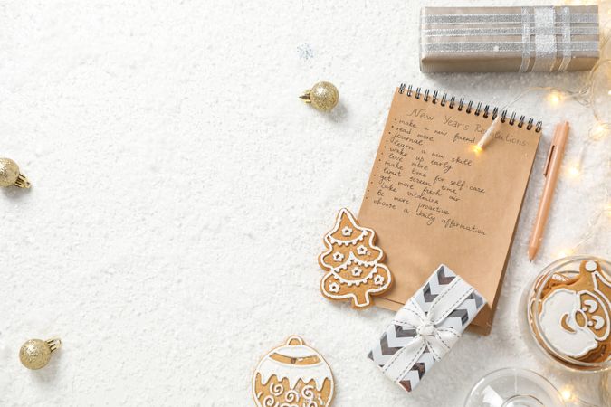 Cookies, gift box and notepad with list on light background, space for text