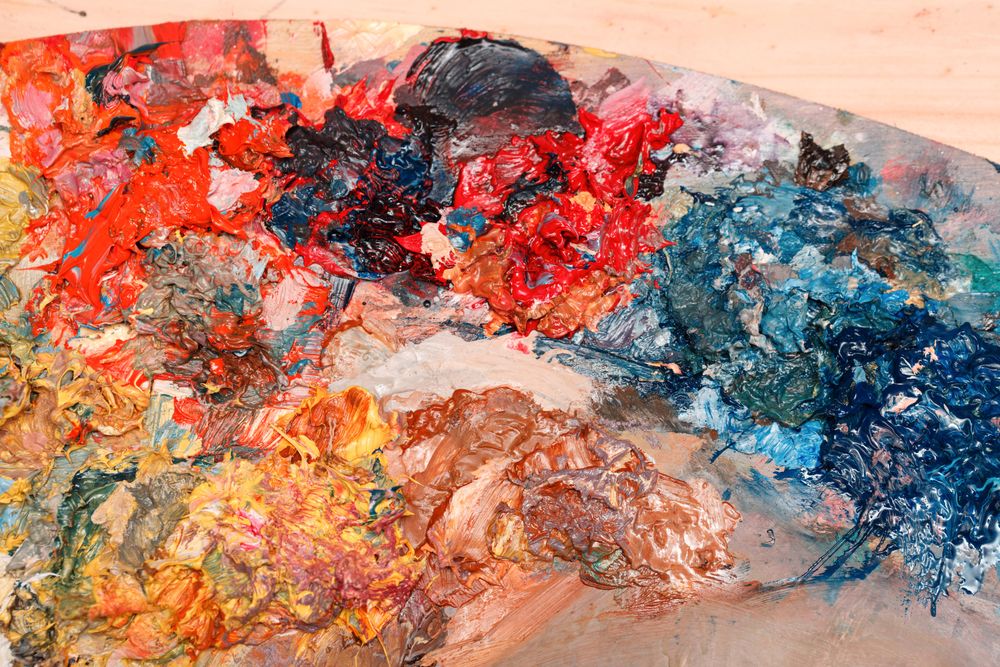 Painter palette with mixed dark paints