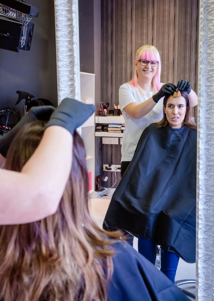 Hairdresser showing different color swathes to client in salon