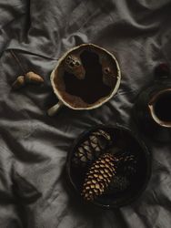 Top view of Turkish coffee surrounded by pine cones on grey sheets