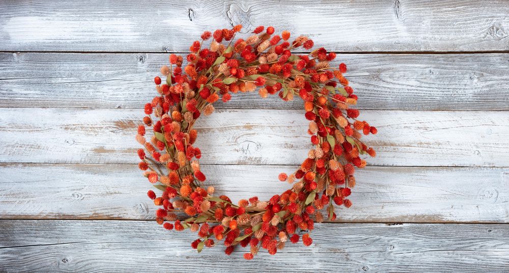 Wreath made of natural burdock flowers on light aged wood