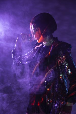 Stylish woman singing on stage