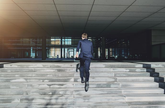 Rearshot of businessman running fast upstairs