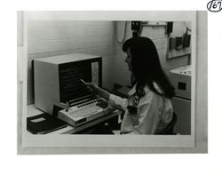 Pharmacist seated at a computer terminal bxvmZ5