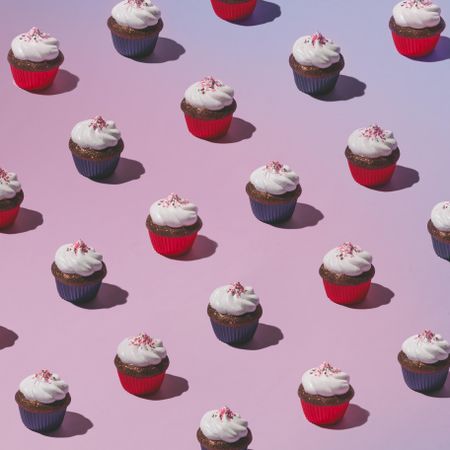 Rows of cupcakes on pink background